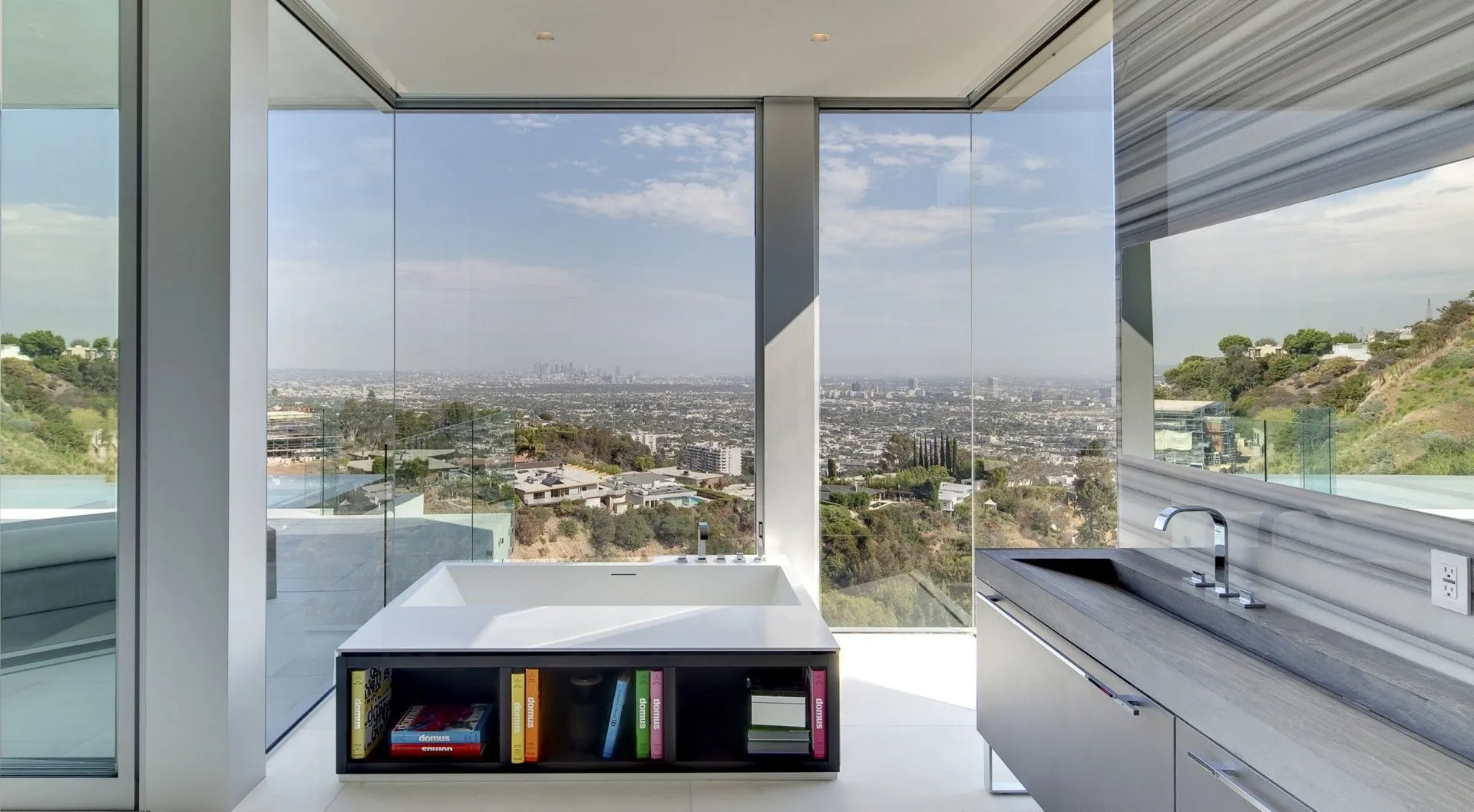 Glass-walled bathroom with city views