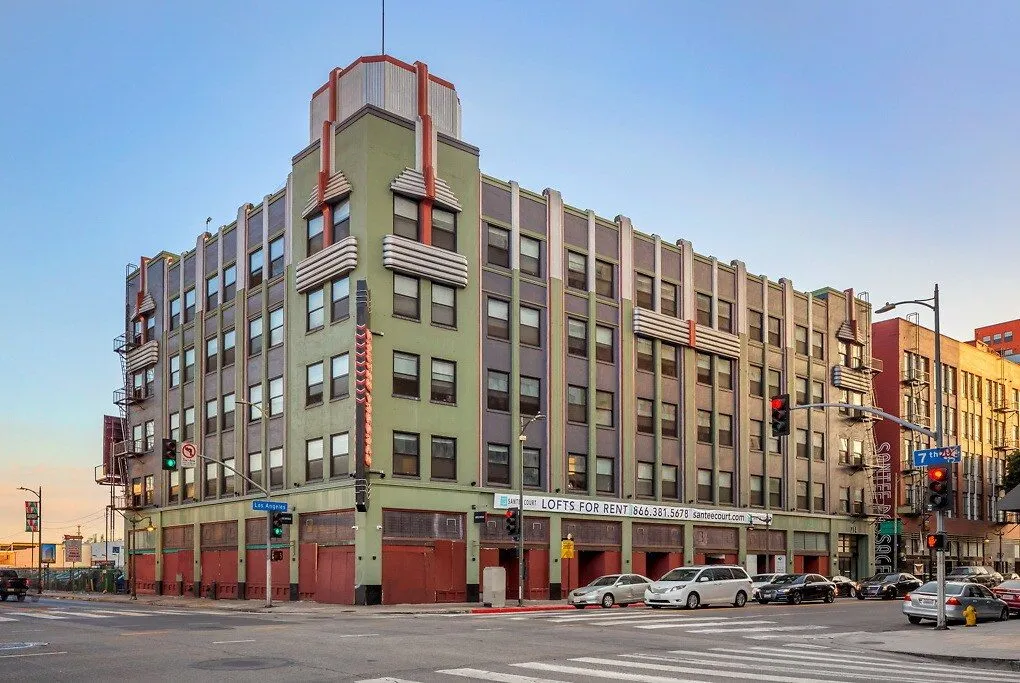 Restored 1912 Art Deco corner building at Santee Court with a stepped tower and ground-floor retail, Downtown LA Fashion District
