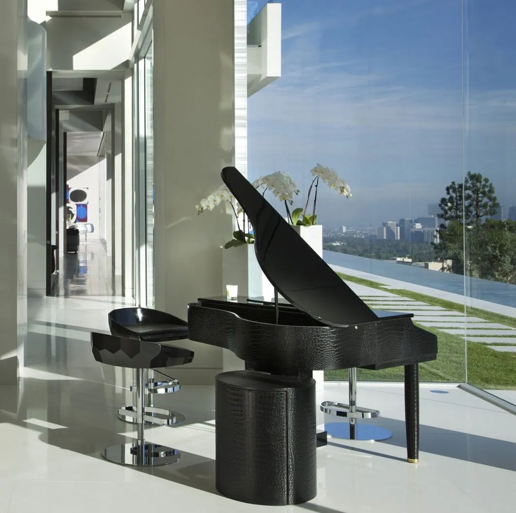 Grand piano beside a glass wall with city views