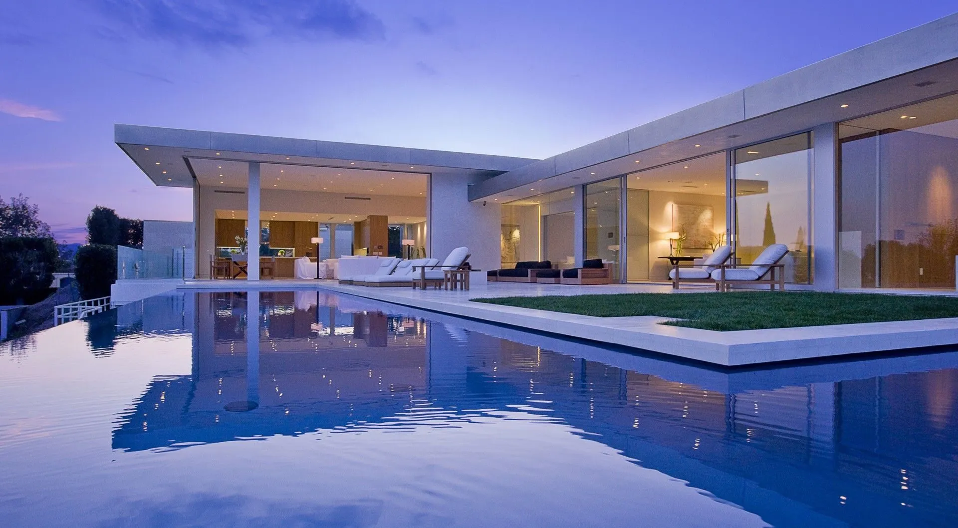 Tanager I pool wrapping the residence at dusk