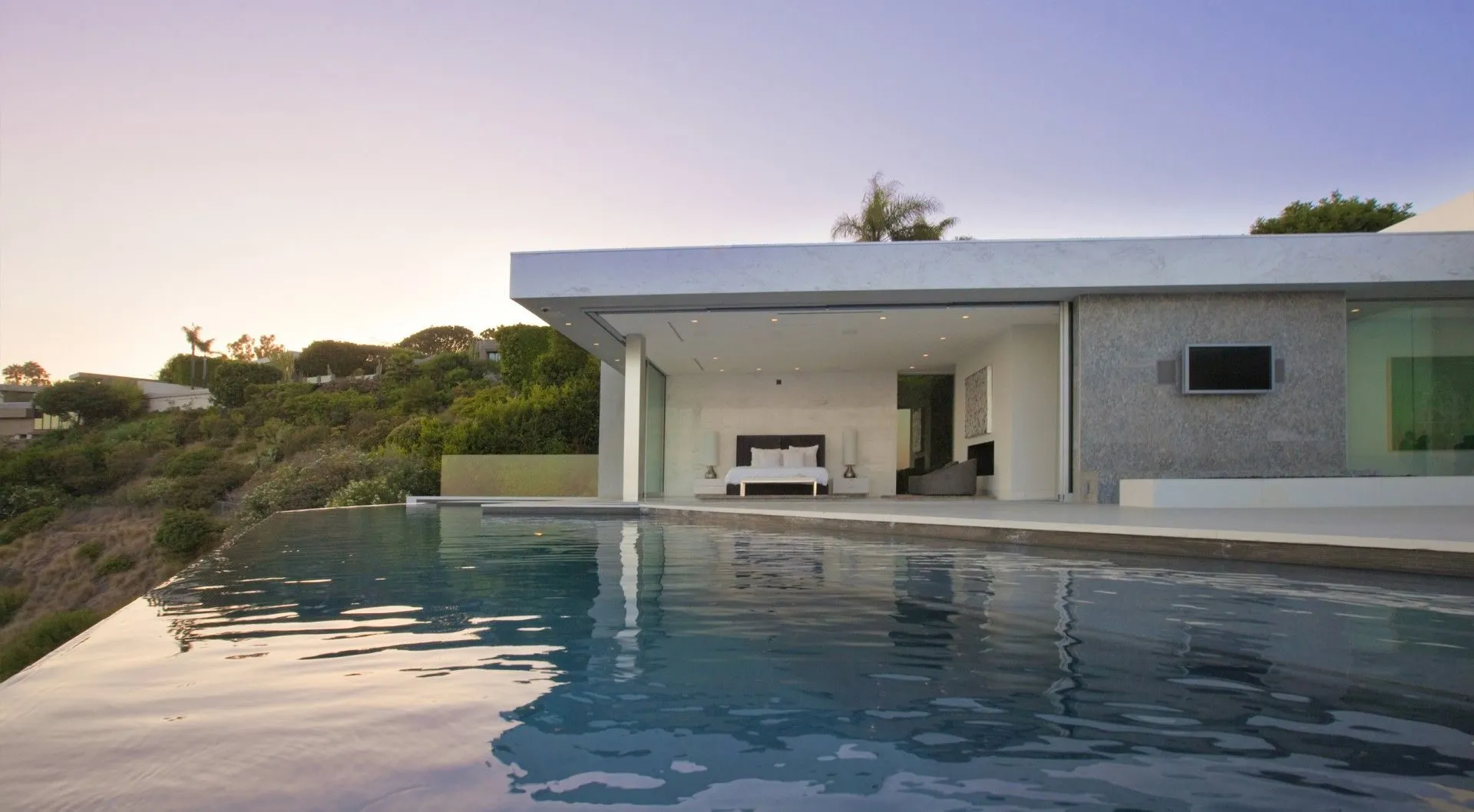 Bedroom pavilion and infinity pool at dusk