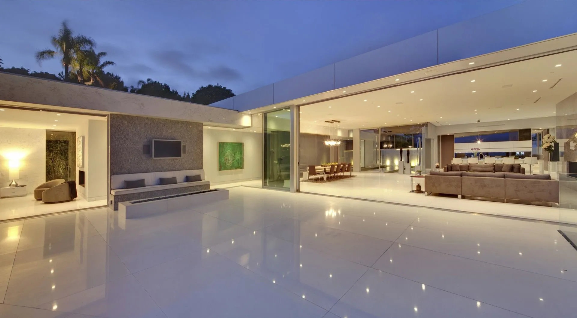 Reflective courtyard and living room at twilight
